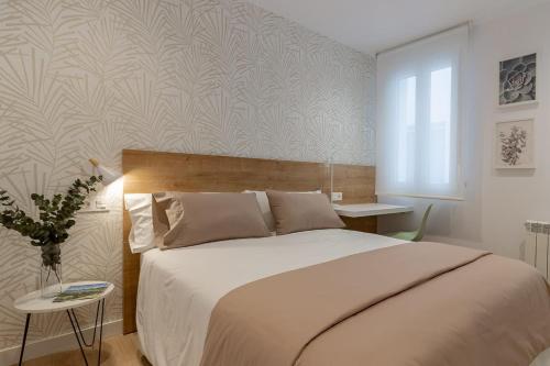 奥维多Room4You Oviedo by Asturias Holidays的一间卧室配有一张大床和一张桌子