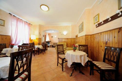 佩斯卡塞罗利Albergo Pensione Paola的一间在房间内配有桌椅的餐厅