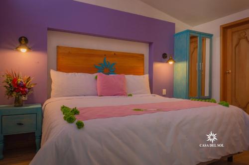 圣克里斯托瓦尔-德拉斯卡萨斯Hotel Casa del Sol的一间卧室设有一张紫色墙壁的大床