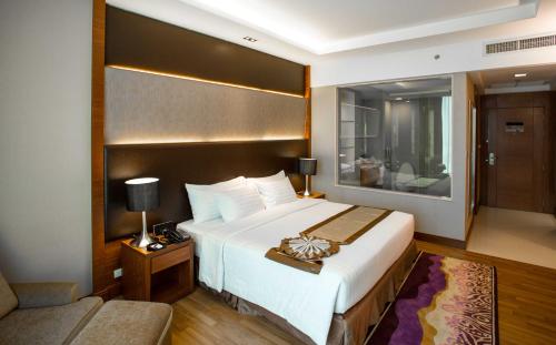 曼谷曼谷飞越大酒店的酒店客房设有一张大床和一张沙发。