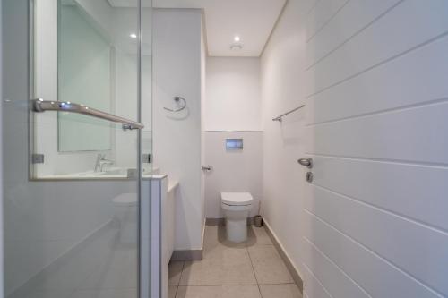 SibayaUnit 215 Oceandune - Stunning & Modern Apartment的一间带卫生间和玻璃淋浴间的浴室