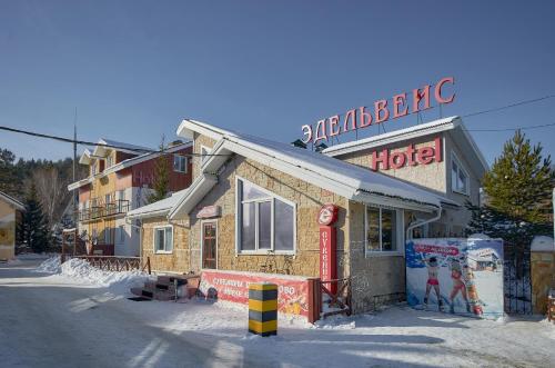 阿布扎科沃Edelweiss Hotel的雪上标有标志的酒店
