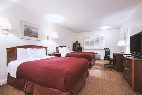 麦库克Sky-Palace Inn & Suites McCook的酒店客房设有两张床和一台平面电视。