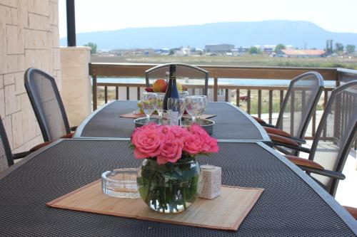 普洛切Guesthouse San Antonio的一张桌子,上面有花瓶,上面有粉红色的玫瑰花