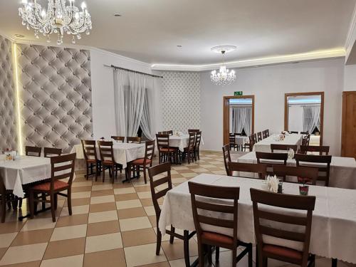 NiskoZajazd Pod Jesionami的一间带桌椅和吊灯的用餐室