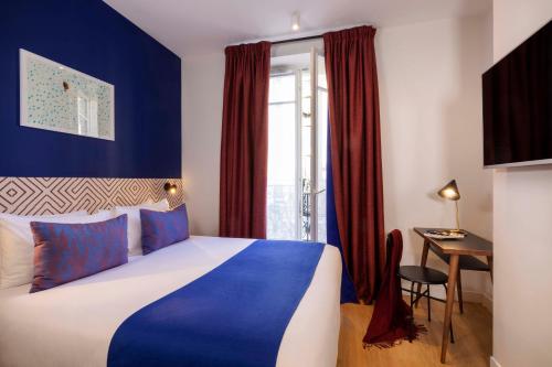 巴黎Paris Art Hotel Quartier Latin by Malone的卧室配有蓝色和白色的床和书桌。
