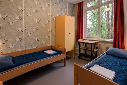 阿纳姆Stayokay Hostel Arnhem的一间卧室设有两张双层床和一扇窗户。