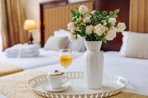 诺维萨德Garni Hotel Planeta Inn的花瓶桌子和酒盘