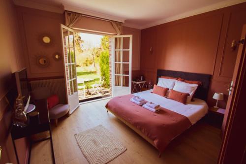 赫恩Les jardins de Beaumont的一间卧室设有一张大床和一个大窗户