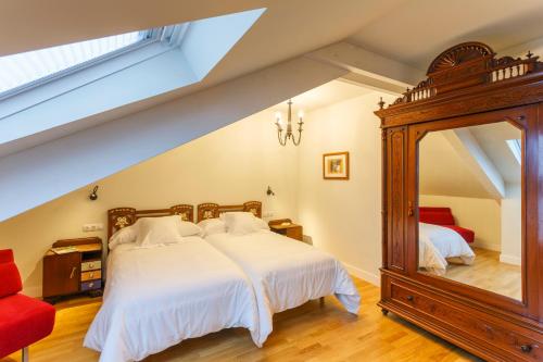 FriolHotel Casa da Galbana的一间卧室配有一张大床和镜子