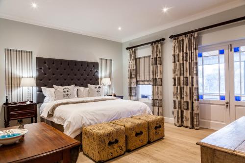 艾伯特王子镇Karoo Masterclass - Accommodation Prince Albert的一间卧室设有一张大床和大窗户