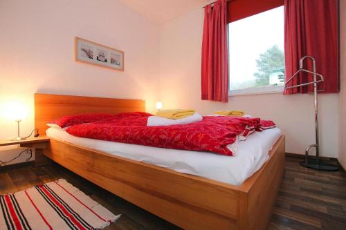 ZislowApartments, Zislow的一间卧室配有一张带红色床单的床和一扇窗户。