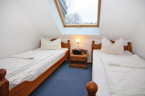 博尔滕哈根Apartment in the Papillon holiday village, Boltenhagen的小型客房设有两张单人床和窗户。