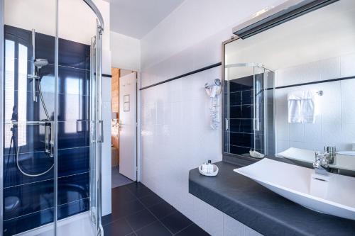 欧迪耶讷海滩酒店餐厅的一间带水槽和玻璃淋浴的浴室