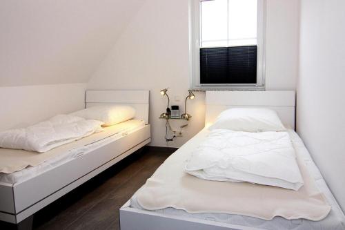 维埃雷格Ferienhaus Lotsenhaus am Breetzer Bodden in Vieregge的白色客房的两张床,设有窗户