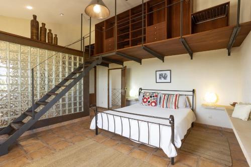 比尼萨勒姆Villa Es Triquet Family的一间带大床和楼梯的卧室