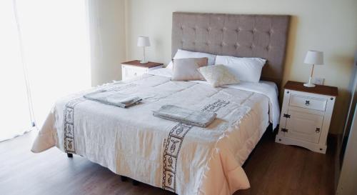 AiguáAmbar Posada Boutique的一间卧室配有一张带2个床头柜的大型白色床