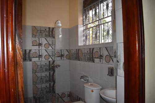 坎帕拉Trinity Resort Hotel & Spa的一间带卫生间和窗户的浴室