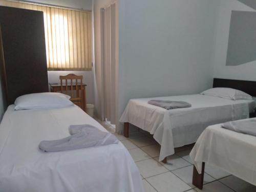 库亚巴Fabiel Palace Hotel的客房设有2张带白色床单的床和窗户。