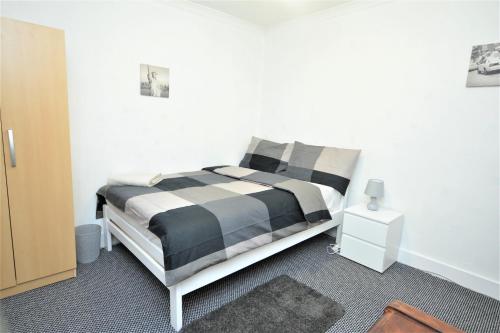 巴尔金Lovely 3 Bedroom House near Barking Station的一间卧室配有一张带黑白枕头的床