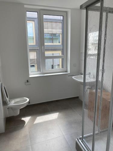 曼海姆Hotel-an-den-Planken的一间带卫生间和两个盥洗盆的浴室以及窗户。