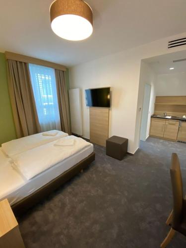 曼海姆Hotel-an-den-Planken的一间卧室配有一张大床和电视
