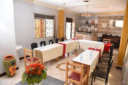 坎帕拉Trinity Resort Hotel & Spa的一间带桌椅和壁炉的用餐室