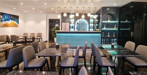 海防IRIS Hotel Hải Phòng的一间带桌椅的餐厅和一间酒吧