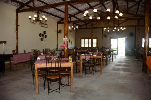 卡舒埃拉斯迪马卡库Hotel Fazenda Chiminelli的用餐室配有桌椅和吊灯。