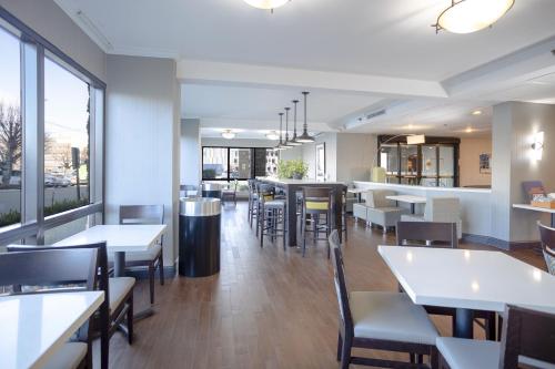 伊丽莎白Holiday Inn Express - Newark Airport - Elizabeth, an IHG Hotel的一间带桌椅的餐厅和一间酒吧