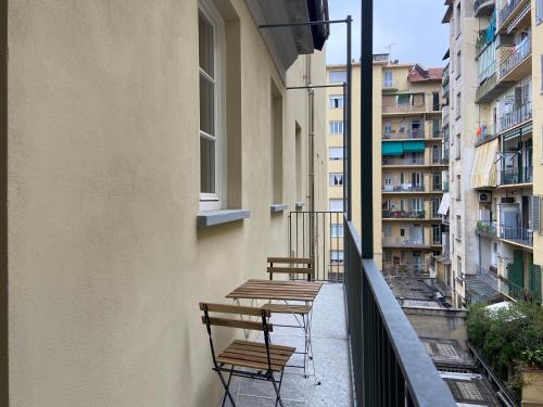 都灵Top Living Apartments - Torino Centro的大楼阳台上的两把椅子和桌子