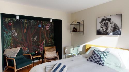 布鲁塞尔Suite lumineuse à Saint-Gilles的卧室配有一张床,墙上挂有绘画作品