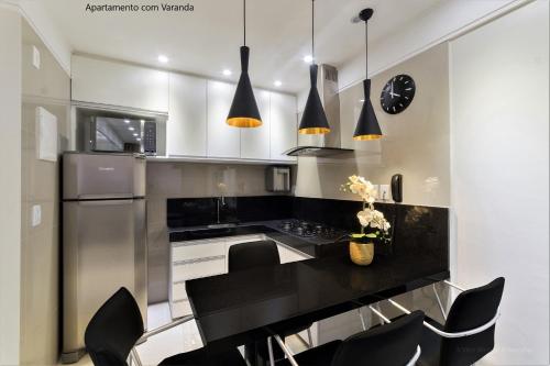 纳塔尔Apto 2Q com varanda no Ed Maximum Home的厨房配有黑色柜台和黑色椅子