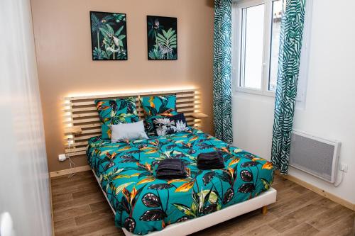 莱齐尼昂科尔比埃Cosy Green Clim Wifi Centre ville 2 pers的一间卧室配有一张带彩色床罩的床