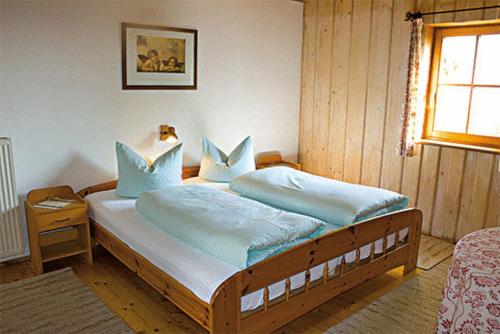 舒奥弗灵多勒霍夫兰德酒店的一间卧室配有一张带蓝色枕头的大床