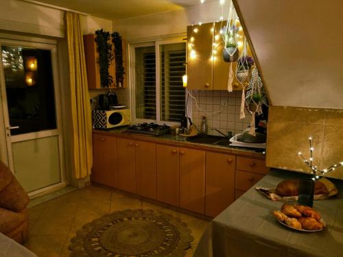 阿拉德נווה מדבר - אירוח מקומי的厨房配有棕色橱柜和一张带一盘食物的桌子