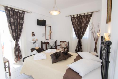 阿莫尔戈斯Pension Ilias - Chora Amorgos的一间带床的卧室,位于带窗帘的房间