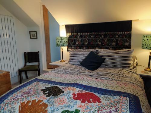 利明顿温泉Offa Home的一间卧室配有一张带彩色床罩的床