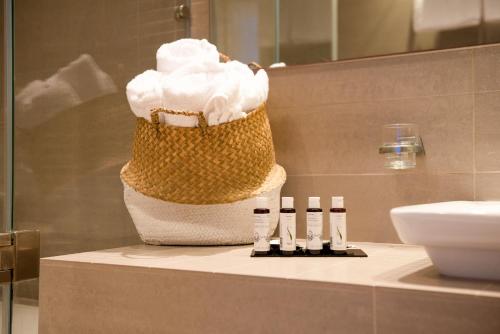 斯基亚索斯镇Iris Skiathos的浴室在柜台上装有一篮 ⁇ 奶油