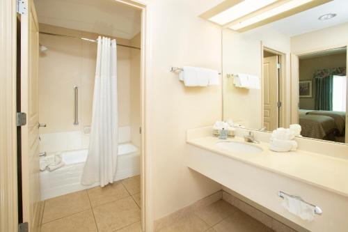 奥兰多Hawthorn Extended Stay by Wyndham Orlando的浴室配有水槽、淋浴和浴缸。
