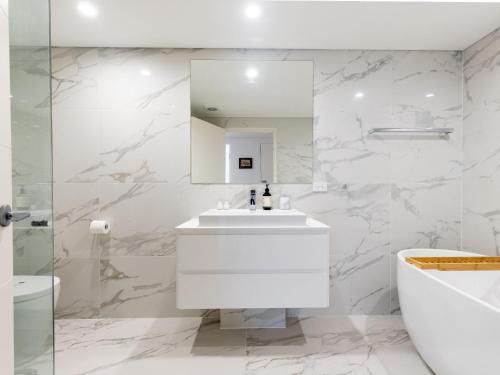 尼尔森湾5 Kingfisher, 5-7 Ondine Close, Nelson Bay, luxury apartment with Wifi and air conditioning的白色的浴室设有水槽和镜子