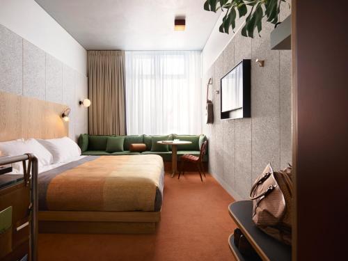 悉尼Ace Hotel Sydney的酒店客房配有床、沙发和桌子。