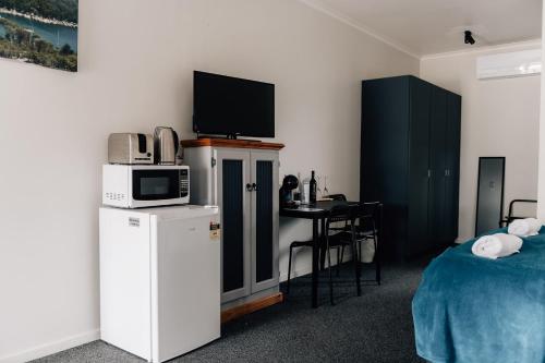 艾伯特港阿尔伯特港汽车旅馆的客房设有床、微波炉和桌子。