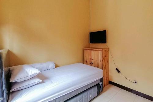 SewanRisqia Syariah TOD M1 Bandara Soekarno Hatta Mitra RedDoorz的一间小卧室,配有一张床和电视