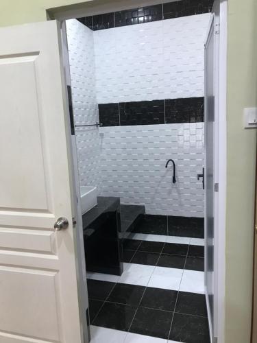 万挠Homestay Islam Keluarga BTP Rawang的浴室铺有黑白瓷砖,设有淋浴。