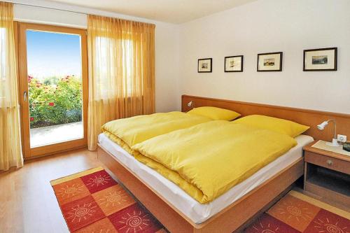 西兰德罗Apartment in Schlanders with terrace的一间卧室配有一张带黄色毯子的大床