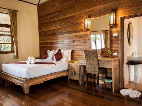 象岛Chaipura Resort的一间卧室配有一张床和一张书桌