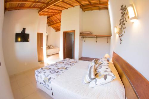 阿瓜斯迪林多亚绿山旅馆的卧室配有白色床和木制天花板