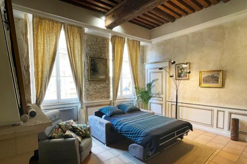 里昂Coeur Vieux Lyon, 60 M2 lumineux tout confort的一间卧室配有一张床、一张沙发和窗户。