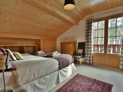莫里永Chalet Esprit的一间卧室设有一张大床和一个大窗户